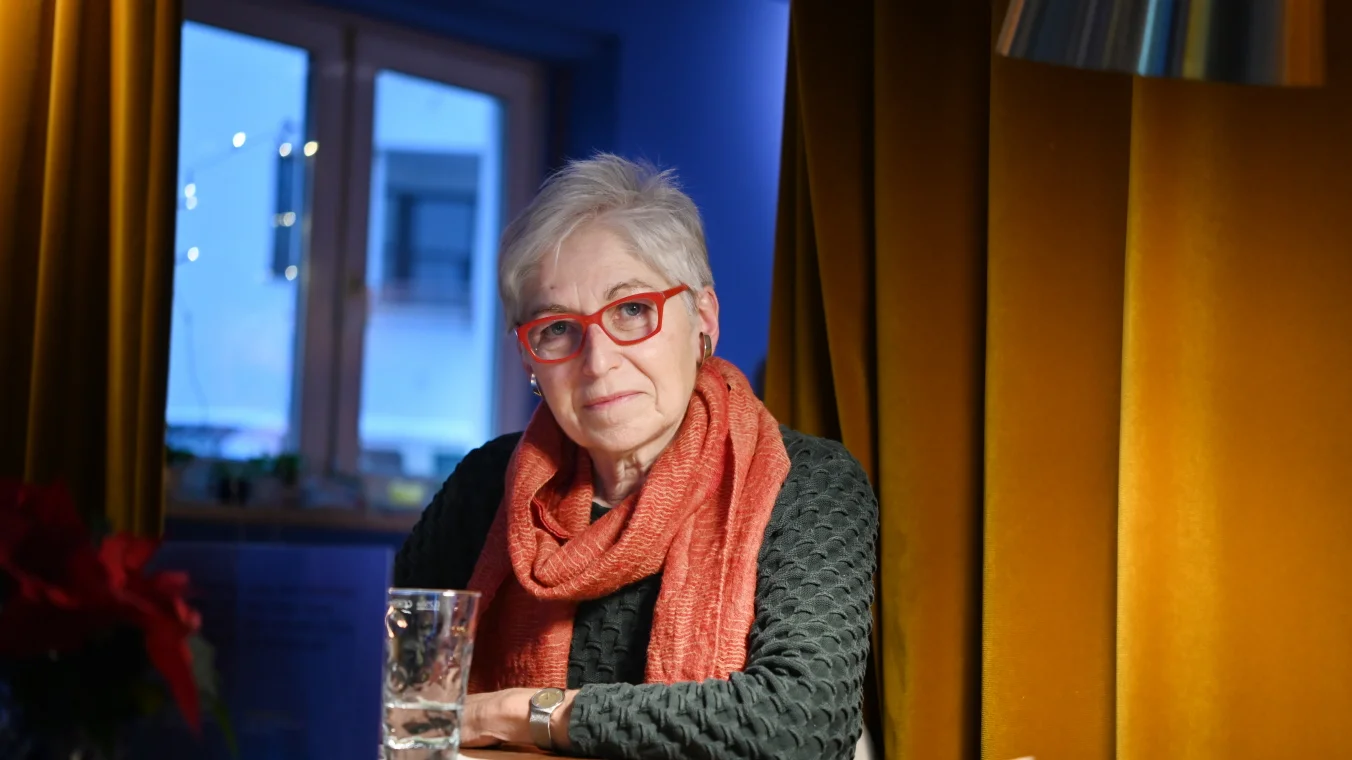 Eigenlebende Irmgard vor dem goldenen Bühnenvorhang im Café eigenleben