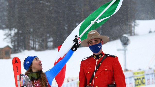 Skifahrerin Sofia Goggia: Mit Flagge und Geleitschutz: Sofia Goggia (links) zelebriert in Lake Louise ihren sechsten Erfolg in der Abfahrt hintereinander.