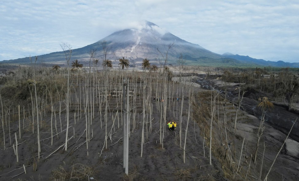 Rescue volunteers carry a body bag at an area affected by the eruption of Mount Semeru volcano in Curah Kobokan, Pronojiwo district, Lumajang