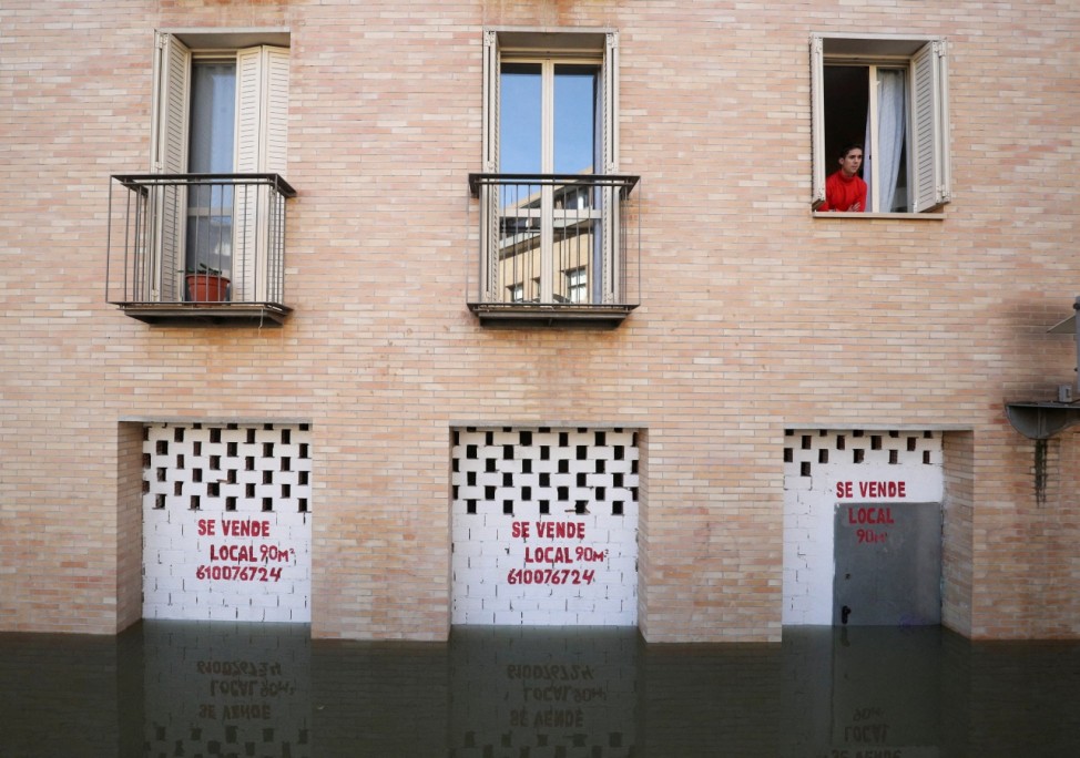 A man at a window speaks with rescue staff patrolling after the River Ebro burst its banks following heavy rains in Tudela
