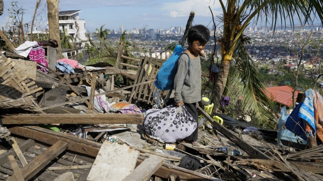 Philippinen: Dieser Junge aus der Provinz Cebu ist in das zerstörte Haus seiner Familie zurückgekehrt und sucht in den Trümmern nach verlorenen Gegenständen.