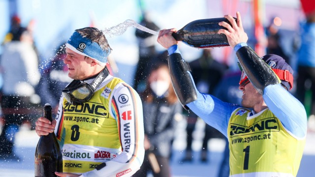 Skifahrer Alexander Schmid: Nasse Haare machen Spaß: Alexander Schmid (links) wird vom Kollegen Luca De Aliprandini mit einer für Siegerehrungen typischen Flüssigkeit begossen, trotz winterlicher Temperaturen.