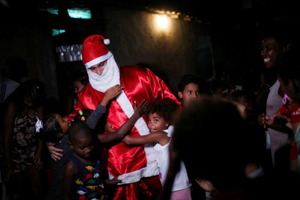 Santa Claus distributes distributes gifts to children during a Christmas party in Cidade de Deus slum, in Rio de Janeiro
