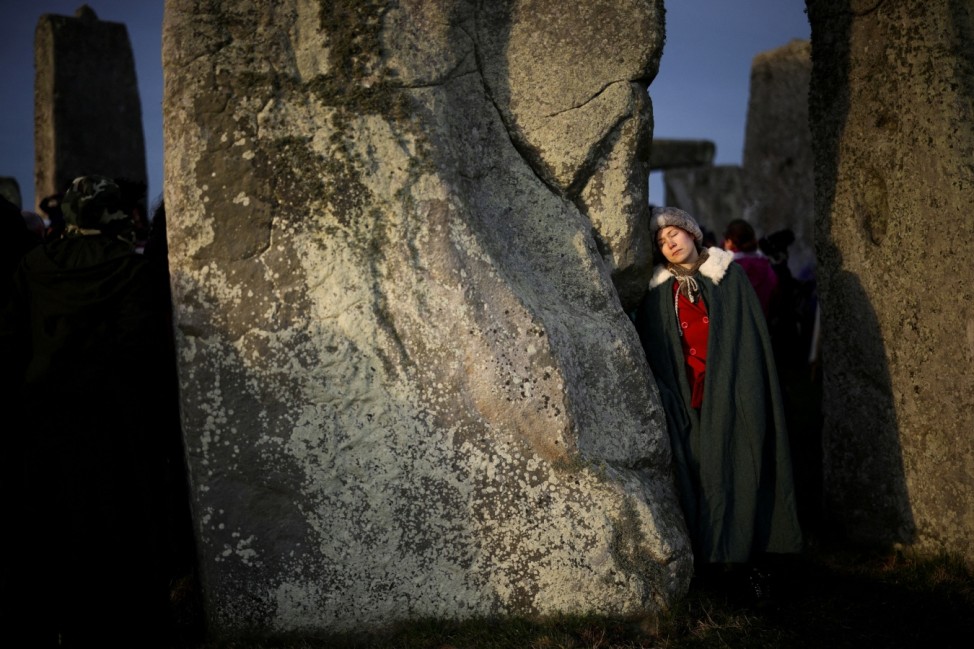 Revellers gather at the Stonehenge stone circle as they welcome in the winter solstice, as the sun rises in Amesbury