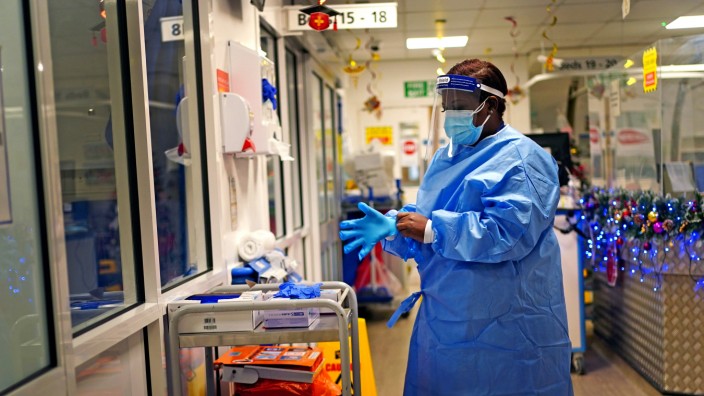 Corona-Virus: Eine Krankenschwester legt im Londoner King's College Hospital Schutzkleidung an. In Großbritannien verdoppelte sich die Zahl der Omikron-Fälle zuletzt alle zwei Tage.