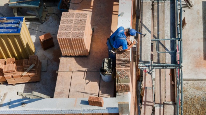 Handwerk: Ein Arbeiter mauert eine Wand auf einer Baustelle im baden-württembergischen Süßen. Die Baubranche in Deutschland boomt, leidet aber unter Nachwuchsmangel.