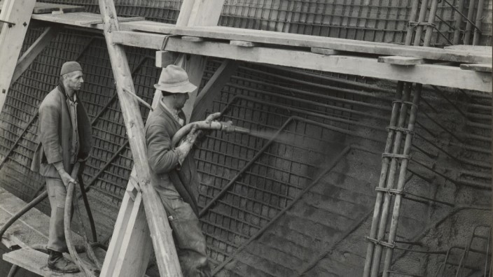 Ausstellung über Beton in der Schweiz: Bauarbeiter tragen 1938 Spritzbeton auf Bewehrungsgitter auf.