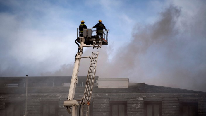 Südafrika: Kapstadt am Sonntag: Feuerwehrleute machen sich von oben ein Bild von der Gefahrenlage am brennenden Parlament.