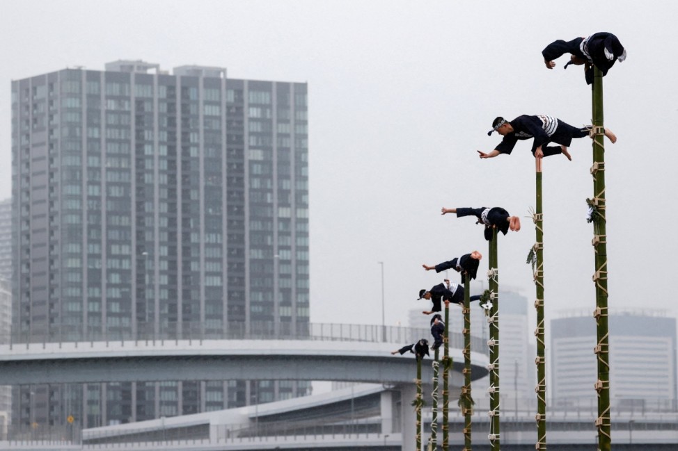 Members of the Edo Firemanship Preservation Association display their balancing skills atop bamboo ladders during a New Year demonstration by the fire brigade in Tokyo