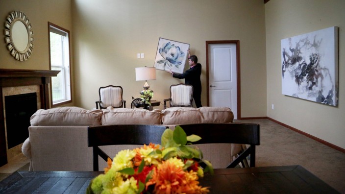 Immobilien: Bilder an den Wänden, ein gemütliches Sofa und indirektes Licht: Home Stager setzen Immobilien zum Verkauf in Szene und erhöhen so Attraktivität und Preis.