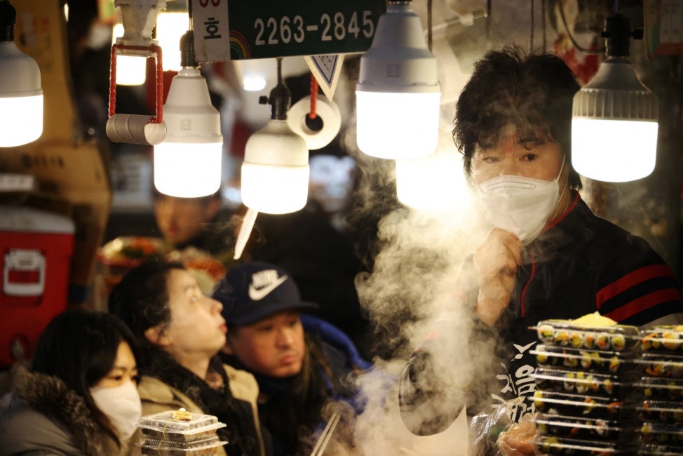 A shopkeeper waits for customers at traditional market in Seoul