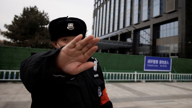 Olympia in China: Kritische Blicke unerwünscht: Ein Sicherheitsmann versucht einen Fotografen daran zu hindern, ein Hotel in der olympischen Blase in Peking zu fotografieren.