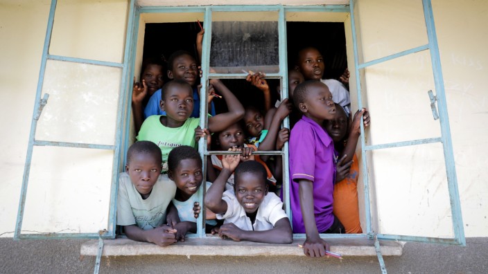 Corona-Krise: Was tut sich da? Flüchtlingskinder aus dem Südsudan beobachten in einem Camp in Uganda eine deutsche Regierungsdelegation.