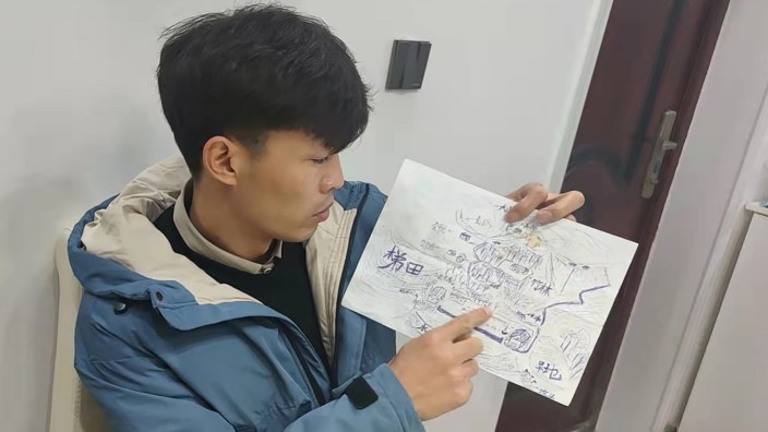 China: Li Jingwei mit der selbst gezeichneten Karte von seinem Dorf. Als Vierjähriger wurde er entführt, mit der Hilfe von Social Media hat er nun seine Mutter und seine Geschwister wiedergefunden.
