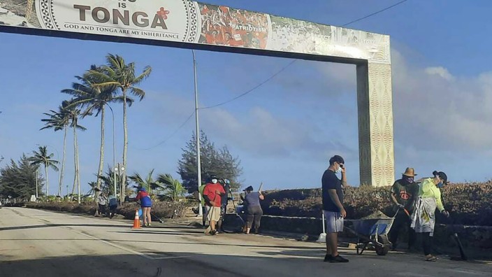 Vulkan in Tonga: Menschen säubern eine Straße in Nukuʻalofa. Sechs Tage nach der Eruption eines Unterseevulkans vor Tonga ist der Flughafen des Südsee-Archipels wieder funktionsfähig.