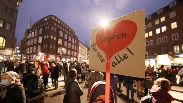 Corona in Deutschland: Demonstrantin mit Schild "Impfen für uns alle"