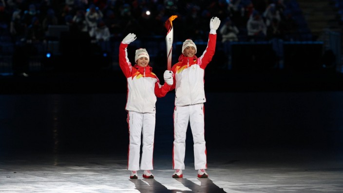 Olympia: Umstrittenes Paar: Dinigeer Yilamujiang (links) und Zhao Jiawen bei der Entzündung des olympischen Feuers im Pekinger Olympiastadion.