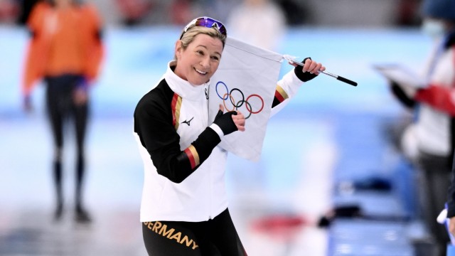 Claudia Pechstein bei Olympia: Schon wieder eine Fahne: Claudia Pechstein kürt sich am Rande des 3000-Meter-Rennens zur Rekordteilnehmerin bei Winterspielen.
