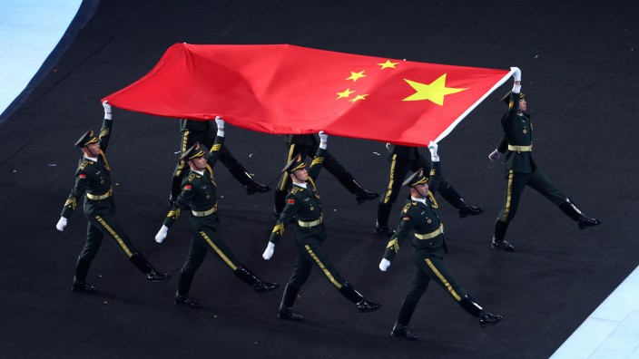 Softpower-Strategie: Gewinnt man so die Herzen der Welt? Soldaten tragen die chinesische Flagge bei der Eröffnungszeremonie der Olympischen Spiele.