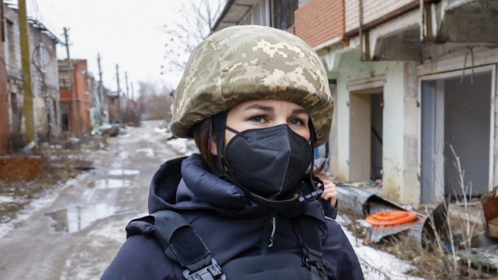 Baerbock in der Ostukraine: Schwarze Schutzweste und Tarnhelm: Pflicht für Außenministerin Baerbock bei ihrem Besuch in dem ukrainischen Dorf Schyrokyne.