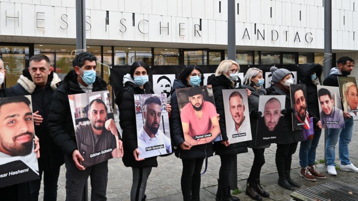 Rechtsextremismus: Angehörige der Opfer des rassistischen Anschlags von Hanau 2020 halten bei einer Mahnwache vor dem hessischen Landtag Fotos der Opfer.