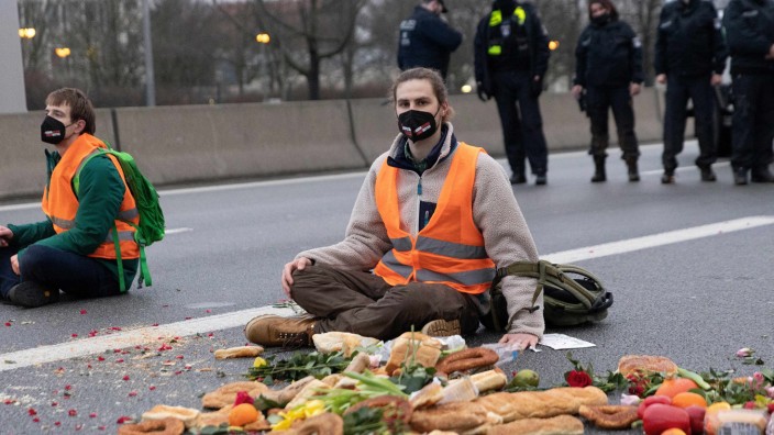 Blockaden der "Letzten Generation": Iss was? Aktivisten der Gruppe "Aufstand der letzten Generation" sitzen auf der A 100 in Berlin, um gegen Lebensmittelverschwendung zu protestieren.