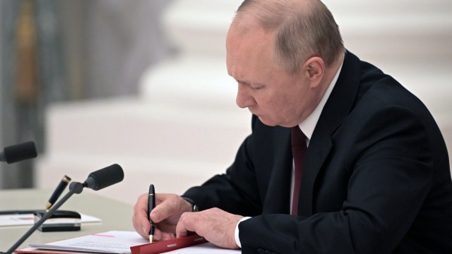 Chronik: Putin am Montag bei der Unterzeichnung des Dekrets, das die Unabhängigkeit der Separatistengebiete im Osten der Ukraine anerkennt.