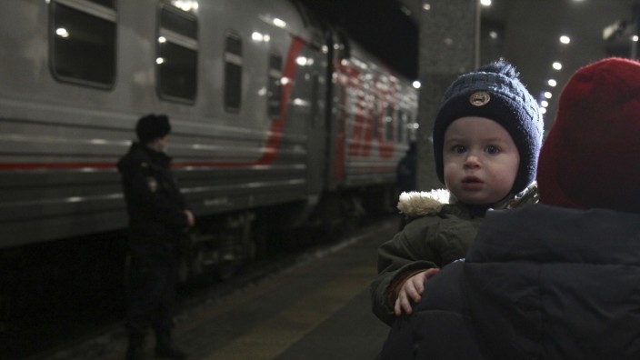 Ukraine-Konflikt: Ein Kind wird während der Evakuierung von Bewohnern aus der Region Donezk am Bahnhof getragen. Der russische Präsident Putin hat Truppen in den umkämpften Osten der Ukraine befohlen.