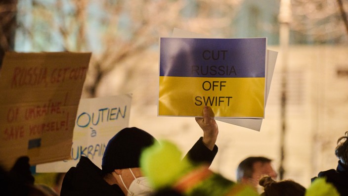 Russland: "Cut Russia off Swift" steht auf einem Transparent, das ein Demonstrant während der Mahnwache zum Ukraine-Konflikt vor der Russischen Botschaft hält. Das hat sich nun erfüllt.