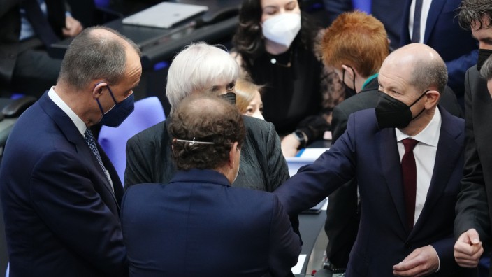 Krieg in der Ukraine: Bundeskanzler Olaf Scholz (rechts) und Oppositionsführer Friedrich Merz (links) unterhalten sich am Rande der Bundestags-Sondersitzung zum Krieg in der Ukraine.