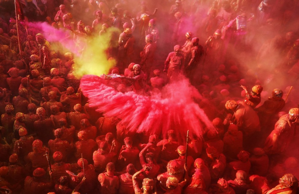 Hindu devotees take part in the religious festival of Holi inside a temple in Nandgaon village