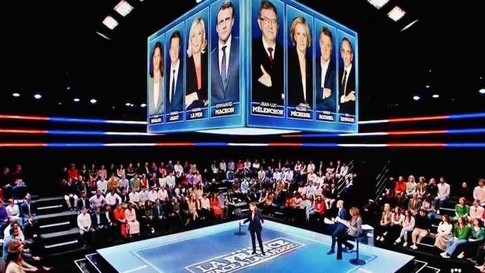 Präsidentschaftswahl in Frankreich: Die Sozialistin Anne Hidalgo auf der Bühne der TV-Präsidentschaftswahldebatte "La France face à la guerre". Über ihr die Bilder aller Kandidatinnen und Kandidaten.