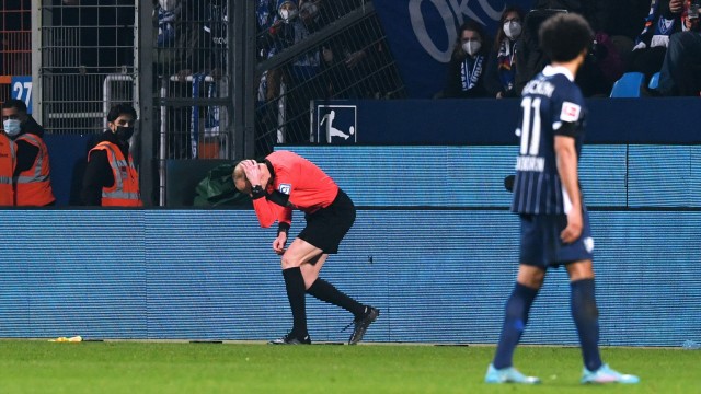 Spielabbruch nach Becherwurf in Bochum: Schiedsrichterassistent Christian Gittelmann hält sich den Kopf, nachdem er von einem Becher getroffen wurde.