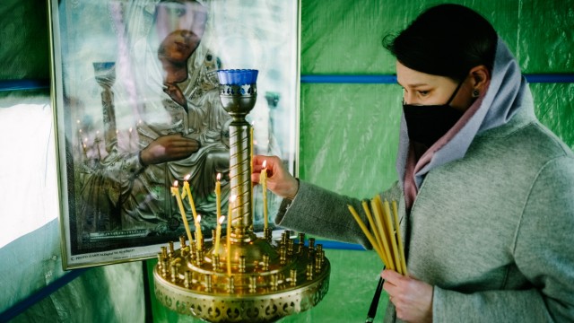 Russisch-orthodoxe Gemeinde: Licht in dunklen Zeiten: Tanja Mannhardt, 43, aus der Ukraine zündet eine Kerze an und betet.