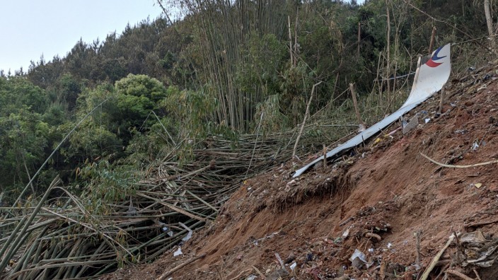 Flugzeugabsturz in China: An der von Bergen umgebenen Absturzstelle bei Wuzhou in der Autonomen Region Guangxi haben die Rettungskräfte neben Trümmerteilen auch Ausweisdokumente und Geldbörsen gefunden.