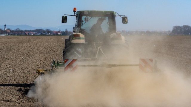 EU-Richtlinie für Lieferketten: Trockene Böden: Ein Landwirt wirbelt mit seinem Traktor beim Bearbeiten eines Feldes Staub auf.