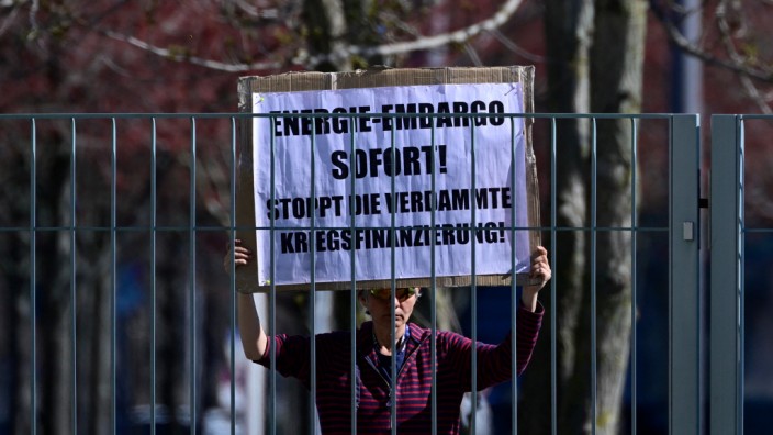 Russland: Vor dem Bundeskanzleramt in Berlin fordert eine Demonstrantin ein sofortiges Energie-Embargo.