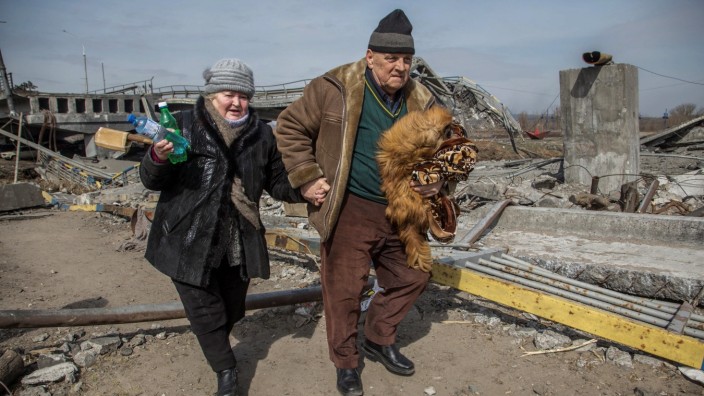 Verhandlungen in Istanbul: Zerstörte Heimat: Ein älteres Paar verlässt die Stadt Irpin nahe Kiew, die bei russischen Angriffen massive Schäden erlitten hat.