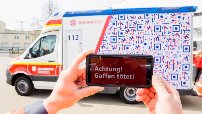 Kampf gegen Gaffer: "Achtung! Gaffen tötet!": Diese Botschaft leuchtet auf dem Handy auf, wenn Schaulustige ihre Smartphone-Kameras auf die neu designten Rettungswagen der Johanniter-Unfall-Hilfe richten.
