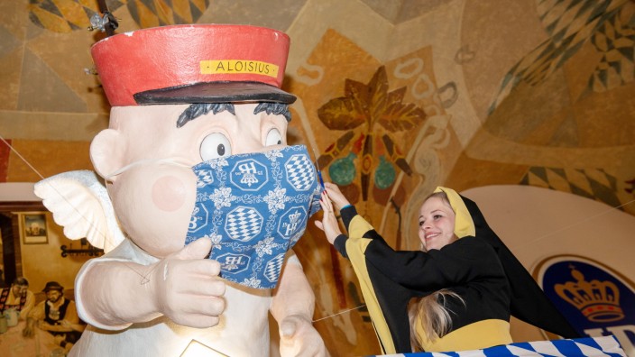 Coronavirus: Freedom Day im Hofbräuhaus: Das Münchner Kindl Viktoria zieht dem Engel Aloisius die Maske vom Gesicht.