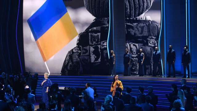 Grammy Awards: Während im Hintergrund Bilder aus der Ukraine gezeigt werden, tritt John Legend in Las Vegas mit der ukrainischen Sängerin Mika Newton auf.