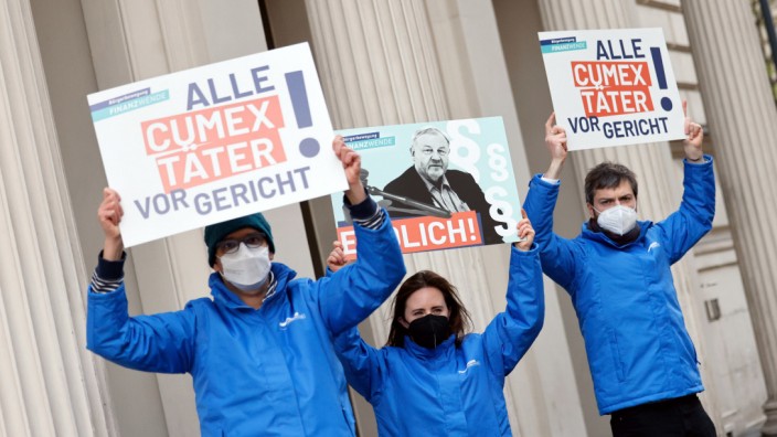 Cum-Ex-Prozess: Aktivisten der "Bürgerbewegung Finanzwende jetzt" demonstrieren vor dem Landgericht Bonn. Auf dem mittleren Plakat ist Hanno Berger zu sehen.