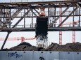 Ein Bagger entlädt in Offenbach Kohle, die in einem Kraftwerk verfeuert werden soll