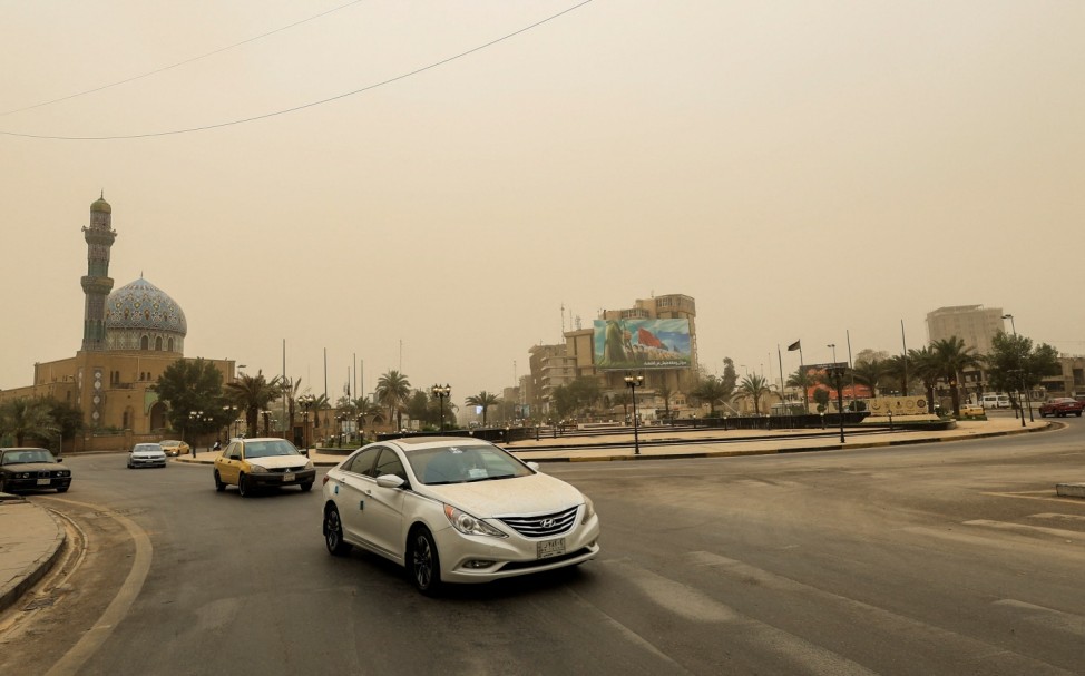 Cars drive amidst a sandstorm on a road, in Baghdad