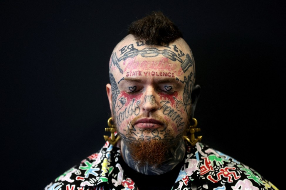 A man poses for a photograph at the Tattoo Tea Party at the Central Convention Centre in Manchester