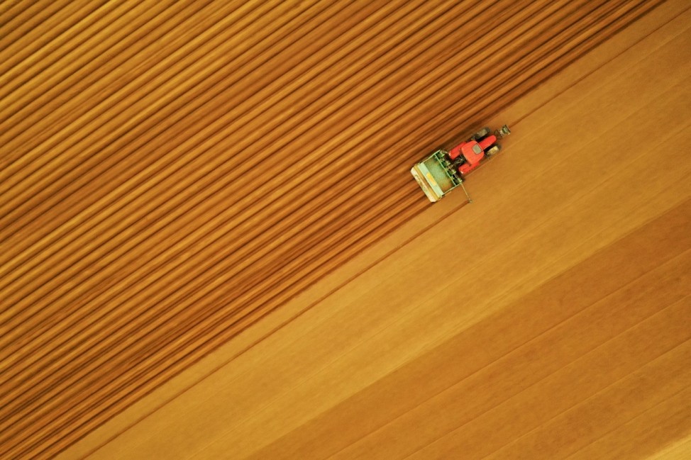 A farmer drives a tractor in his field while planting potatoes in Tilloy-lez-Cambrai