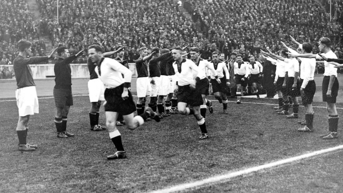 Nationalsozialismus: Fußball im Zeichen des Nationalsozialismus: 1936 laufen die Mannschaften aus Deutschland und Italien mit dem Hitlergruß zu einem Länderspiel ins Berliner Olympiastadion ein.