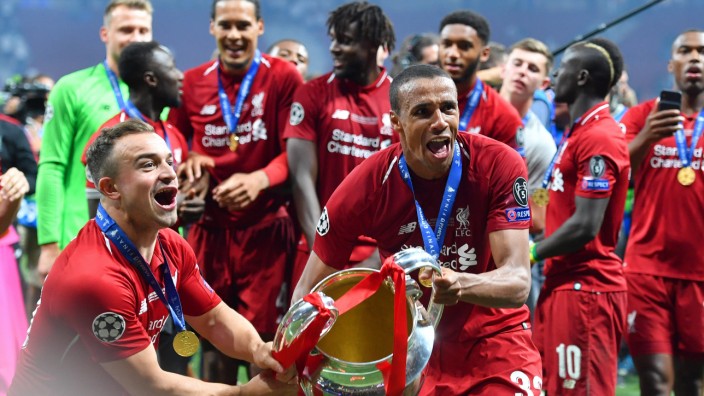 Liverpool-Verteidiger Joël Matip: Schon mal beide Hände am Henkelpott: Joël Matip (Mitte) nach dem Champions-League-Triumph des FC Liverpool im Juni 2019.