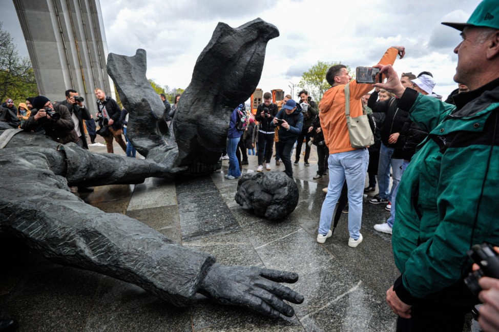April 26, 2022, Kyiv, Ukraine: People take pictures near the dismantled Soviet monument to Ukrainian-Russian friendship,