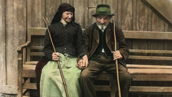 Umgang mit Würdenträgern: Nein, das sind nicht Gerhard Schröder und seine Frau, sondern Altbauer und Altbäuerin vor ihrem Auszugshaus im Salzkammergut, aufgenommen um das Jahr 1910, mit Holzstab statt Mitarbeiterstab.